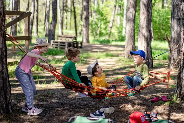 Young children playing and crafting at an outdoor camp